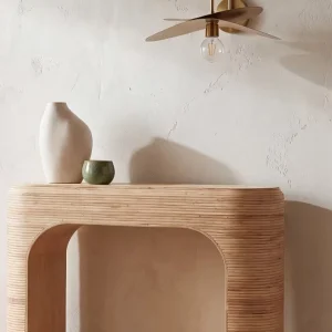 Applique murale zen en laiton et bois au-dessus d'une console arrondie dans une entrée aux murs beiges