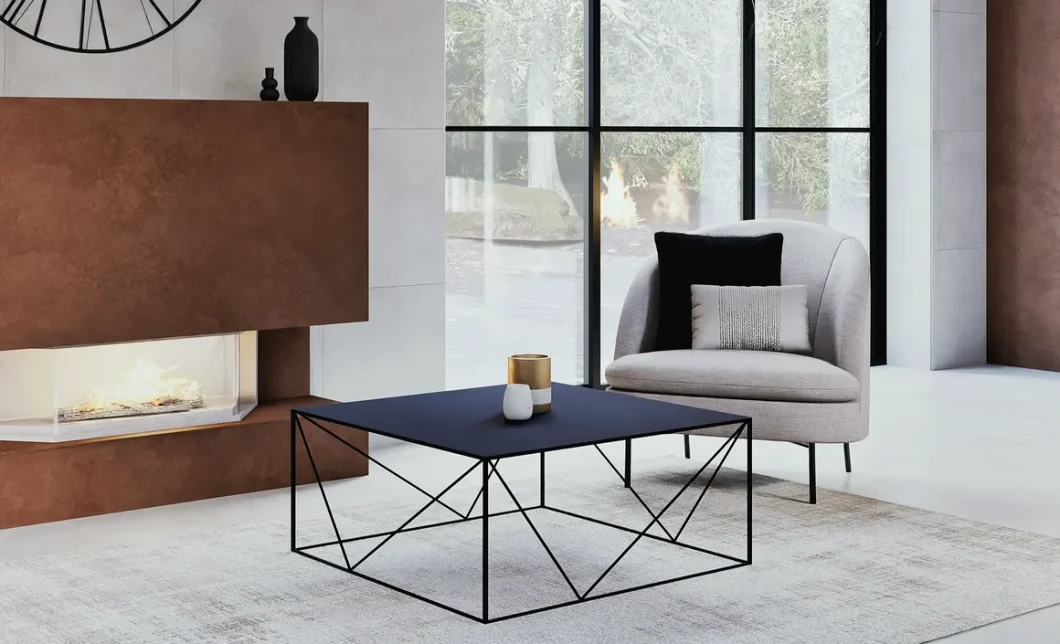 Salon chic avec table basse en métal noir, fauteuil gris et cheminée habillée de métal cuivré