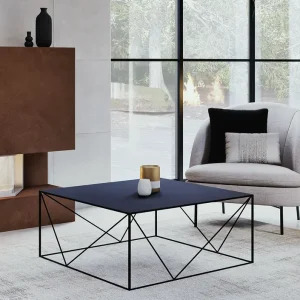 Salon chic avec table basse en métal noir, fauteuil gris et cheminée habillée de métal cuivré