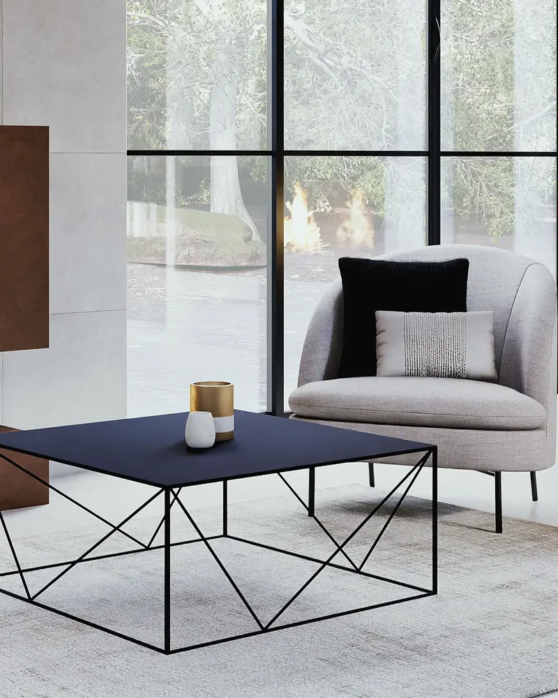 Salon chic avec table basse en métal noir filaire, fauteuil gris et grande verrière