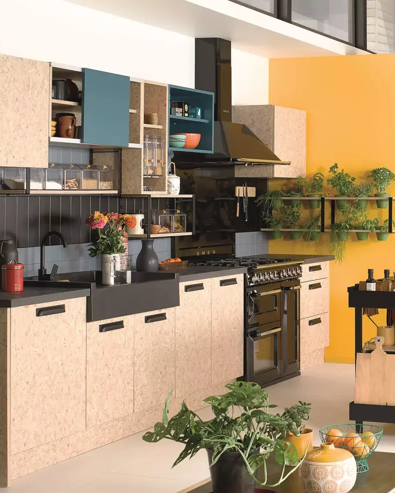 Grande cuisine avec façades de meubles en liège, réfrigérateur inox et mur jaune