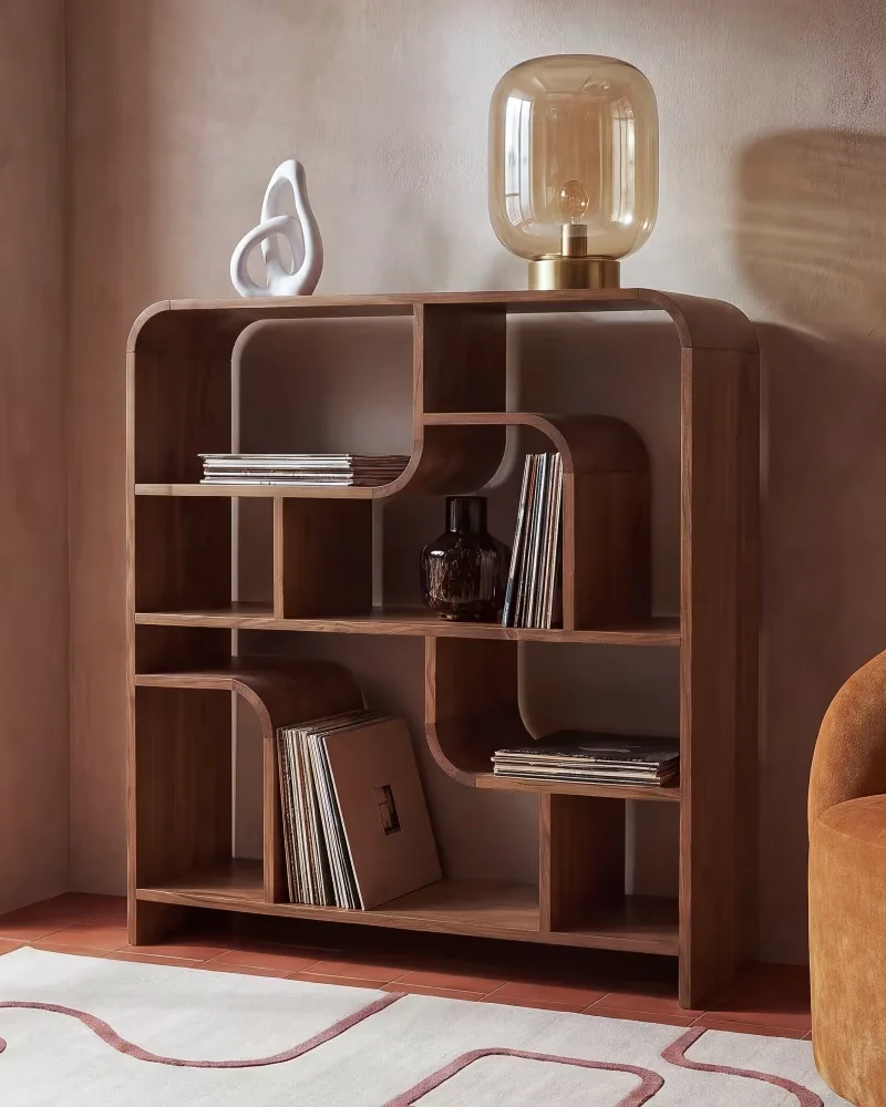 Étagère basse vintage en bois d'acacia aux niches arrondies décorée d'une lampe en verre ambré