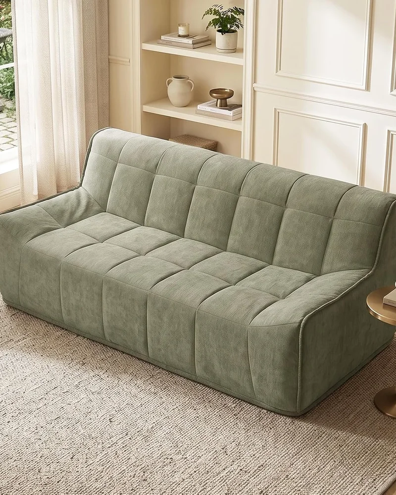 Canapé moderne en chenille vert d'eau à l'assise matelassée dans un salon beige lumineux