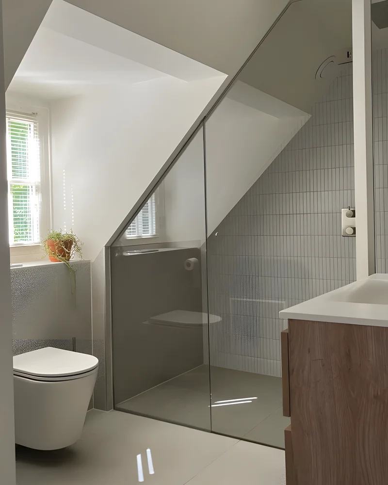 Toilettes sous pente gris et blanc avec douche vitrée, WC suspendu et meuble vasque en bois
