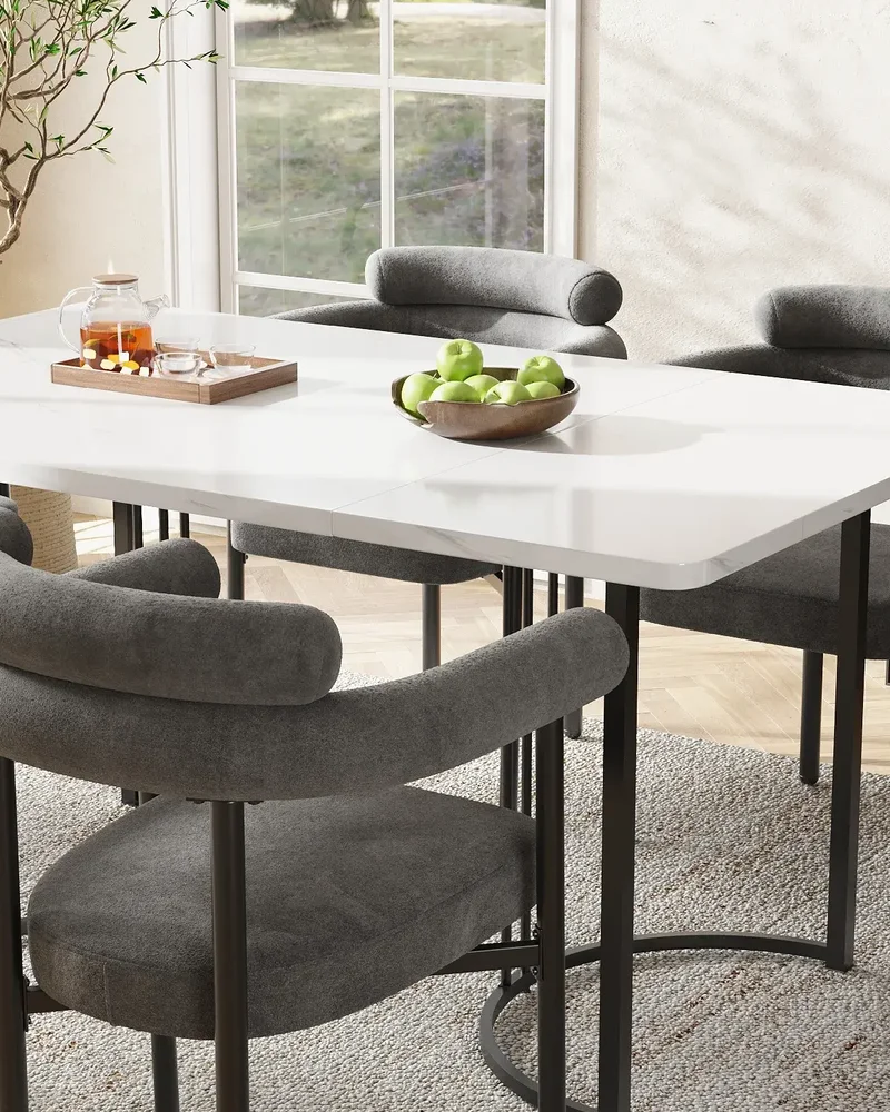 Salle à manger chic avec table blanche, chaises en bouclette grise sur pieds en métal noir et buffet cannelé