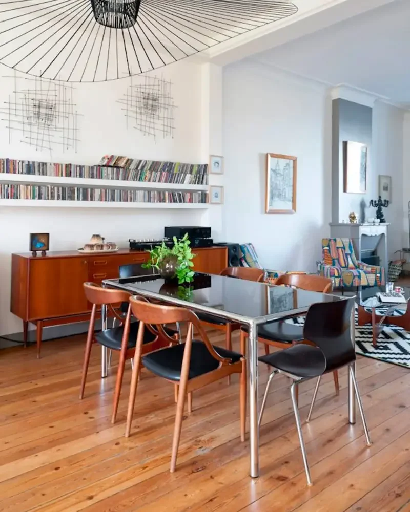 Salle à manger scandinave rétro avec table en verre, chaises en bois courbé et enfilade vintage