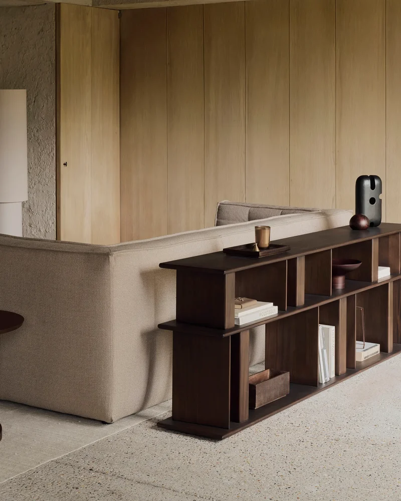 Étagère basse Block en bois d'acajou espresso placée derrière un canapé dans un salon contemporain