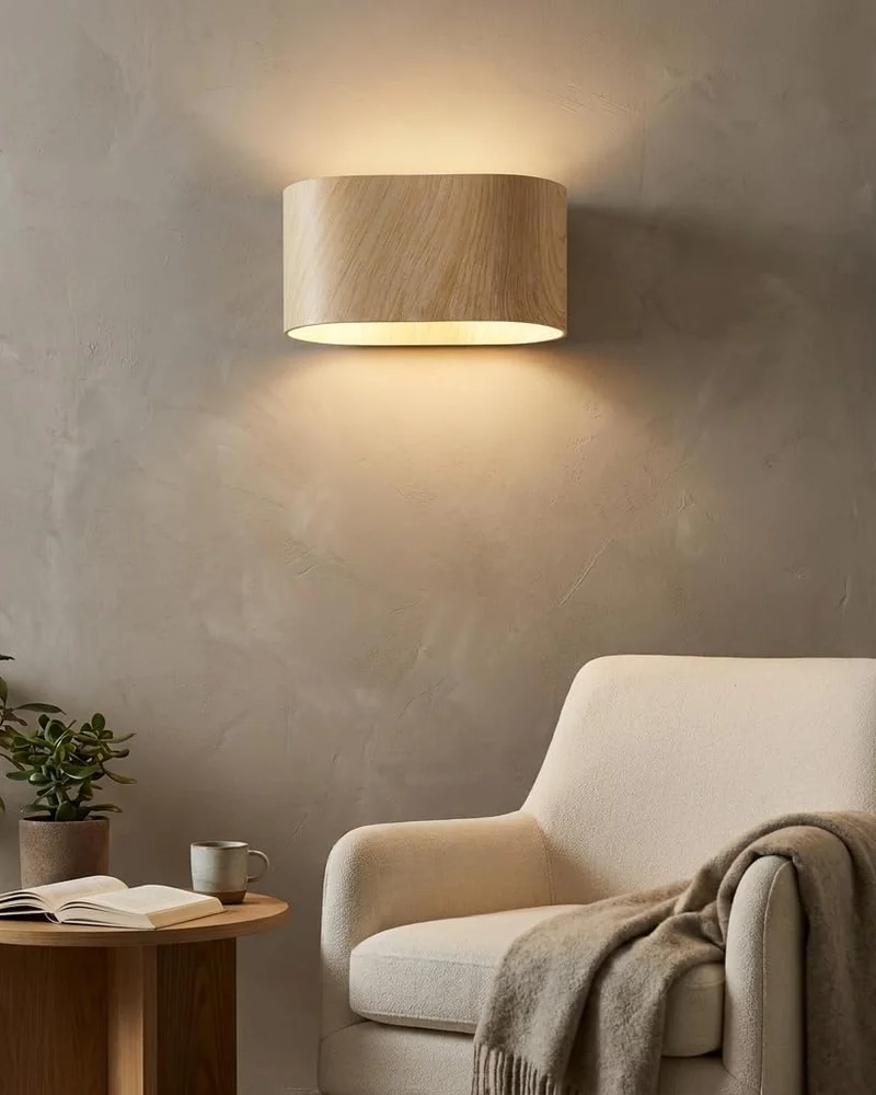 Applique murale zen effet bois clair diffusant une lumière vers le haut et le bas au-dessus d'un fauteuil