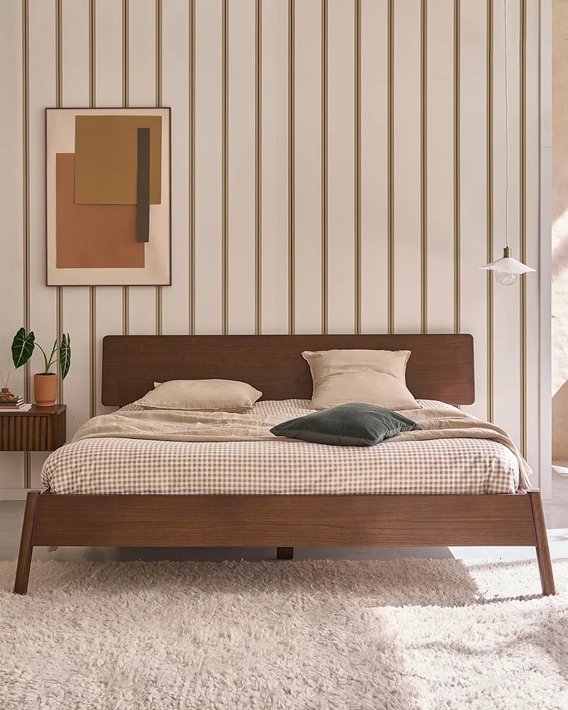Chambre scandinave vintage avec lit en bois sombre, chevet suspendu et mur à rayures beiges